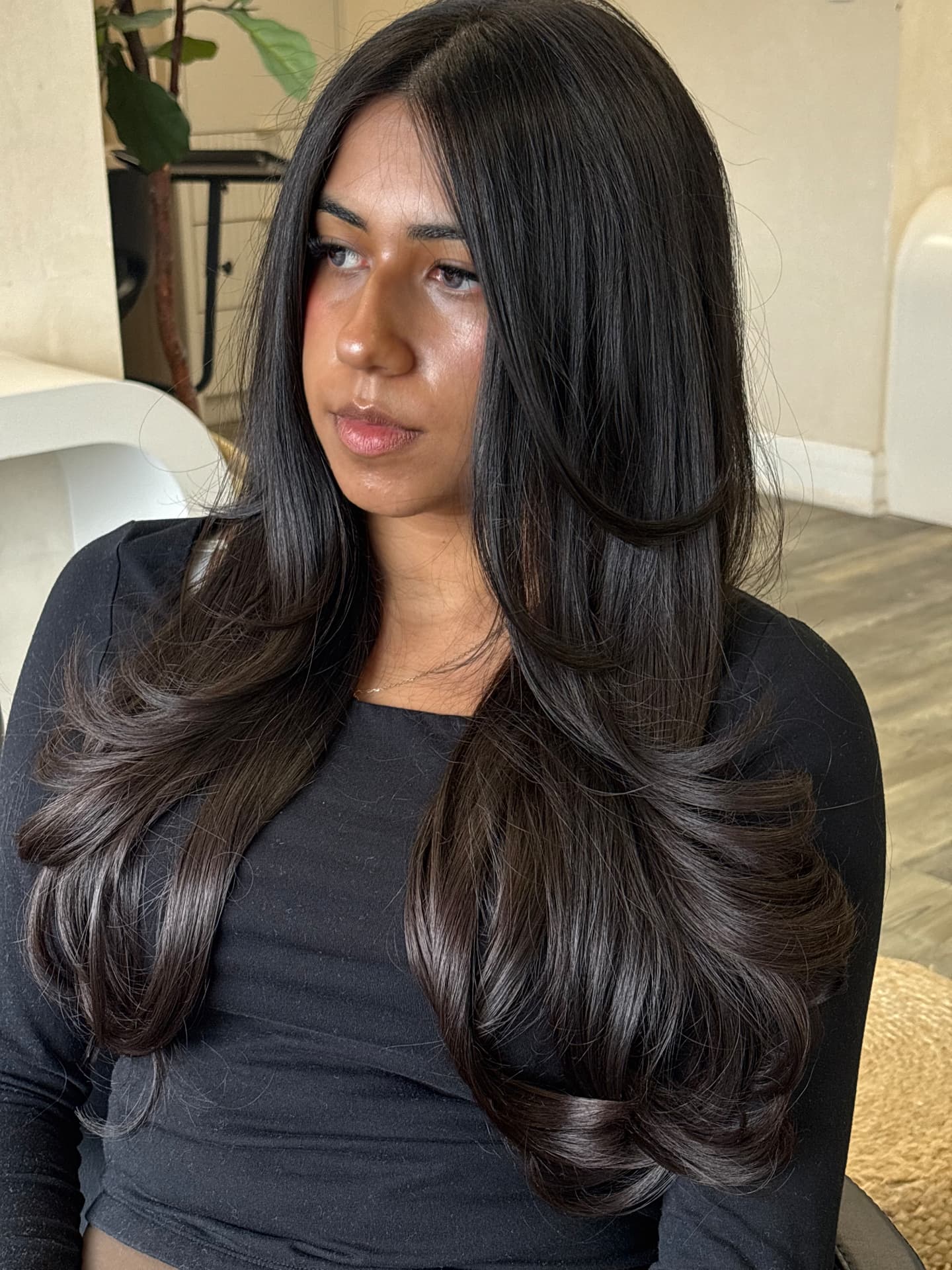 Long layered dark brunette blowout with bouncy curled ends