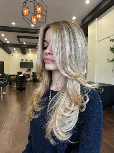 Blonde balayage with layered curtain bangs